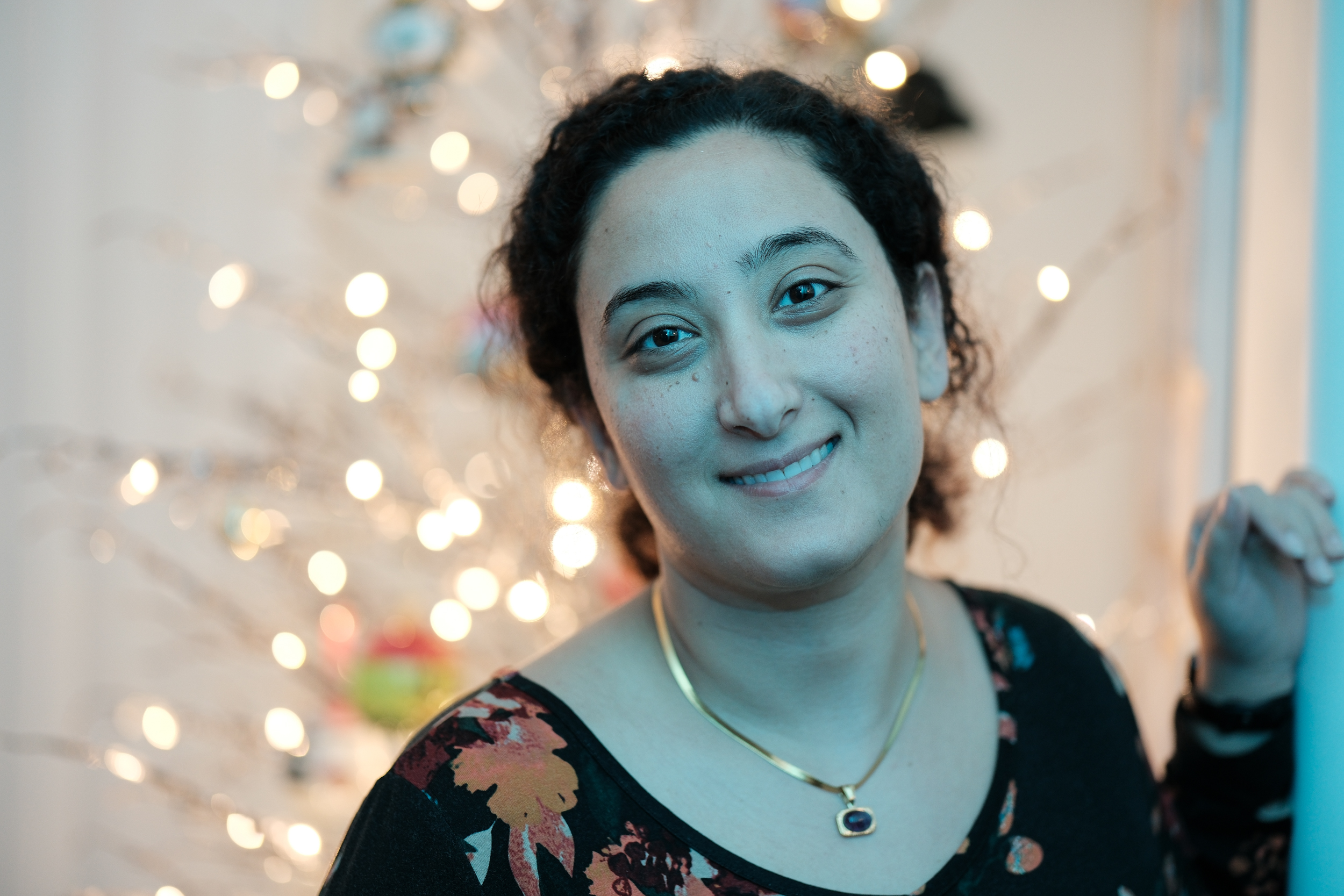 Bunkin's joyful smile beautifully illuminated by the magical glow of festive holiday lights.