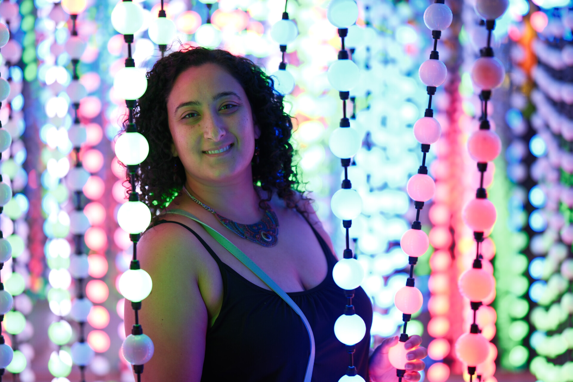 Bunkin' amidst a beautiful installation of hanging colorful lights, her smile serene.