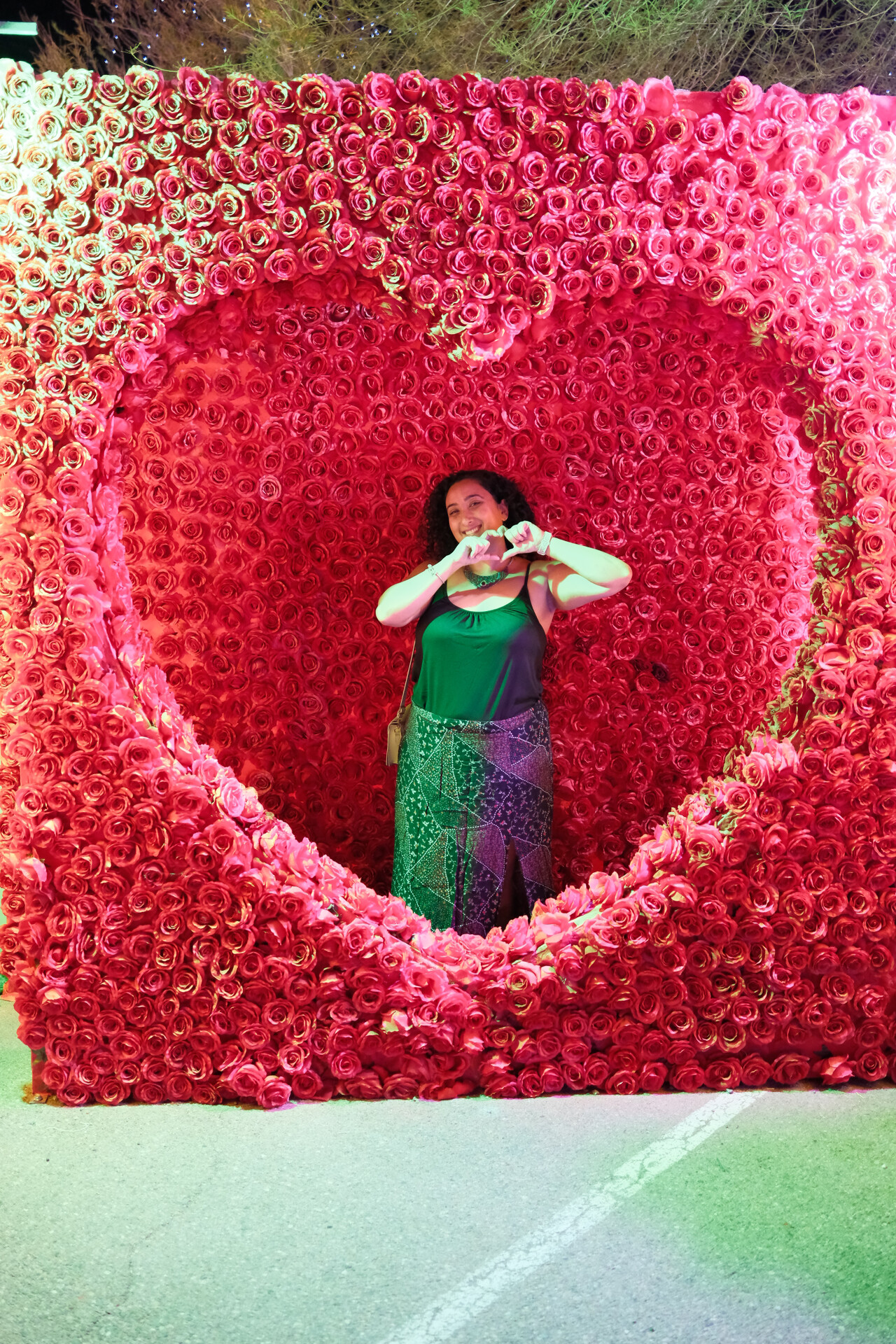Mighty Bunkin' beautifully and joyfully framed by a giant heart of roses, making a heart gesture.