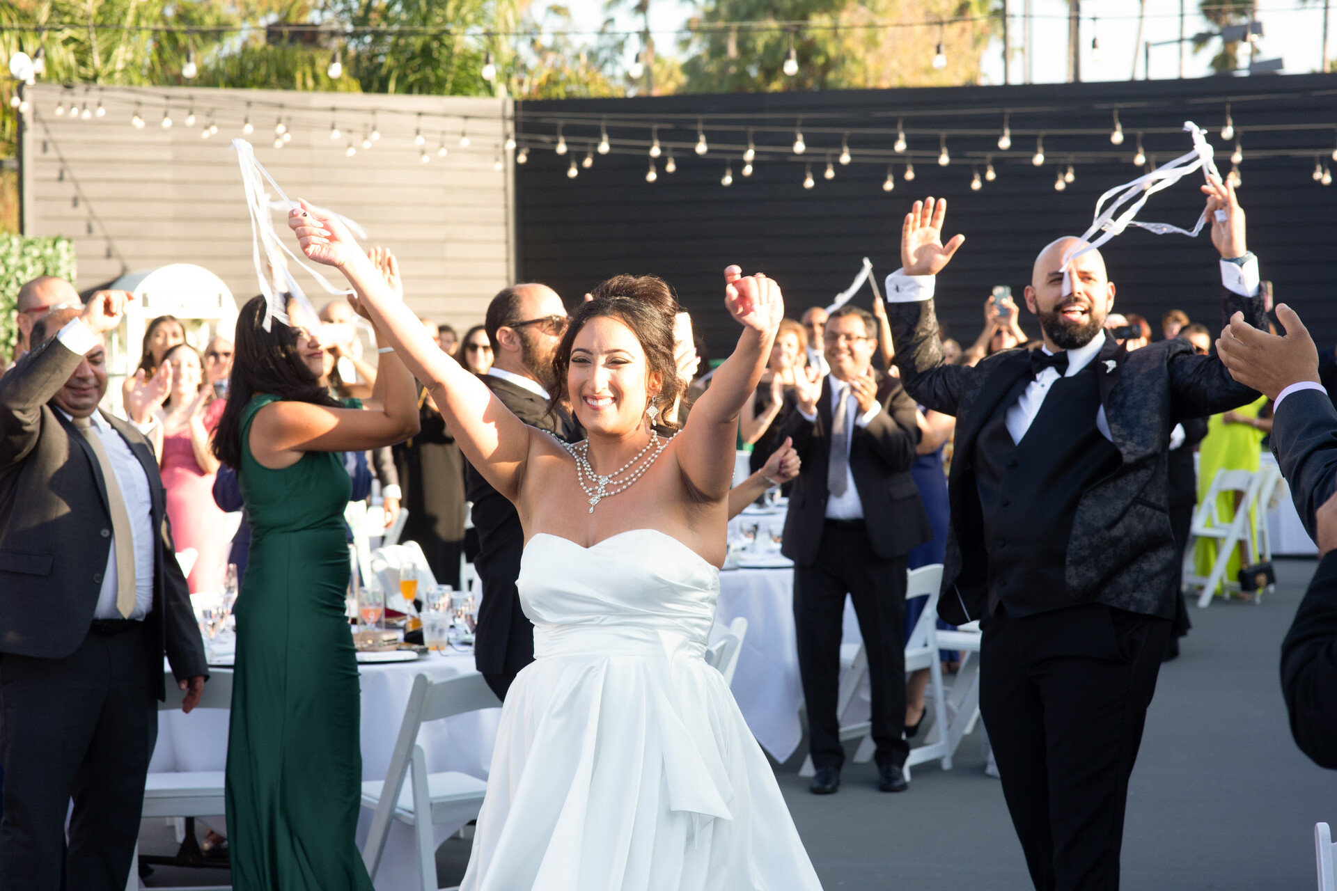 Queen Bunkin' making her grand entrance to the reception, joyfully waving amidst streamers.